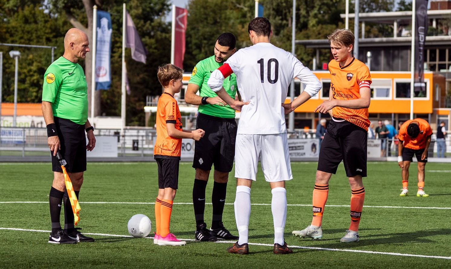 Fender bij de toss op de middenstip, met de scheidsrechters en beide aanvoerders