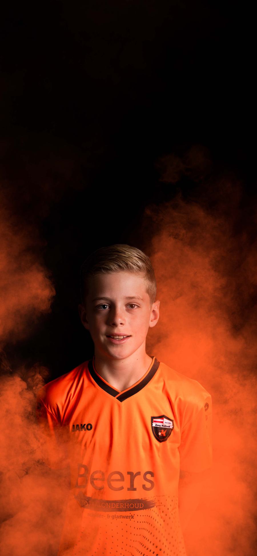Dani van Jongens Onder 12-1 in het nieuwe oranje Beers-shirt, in oranje rook